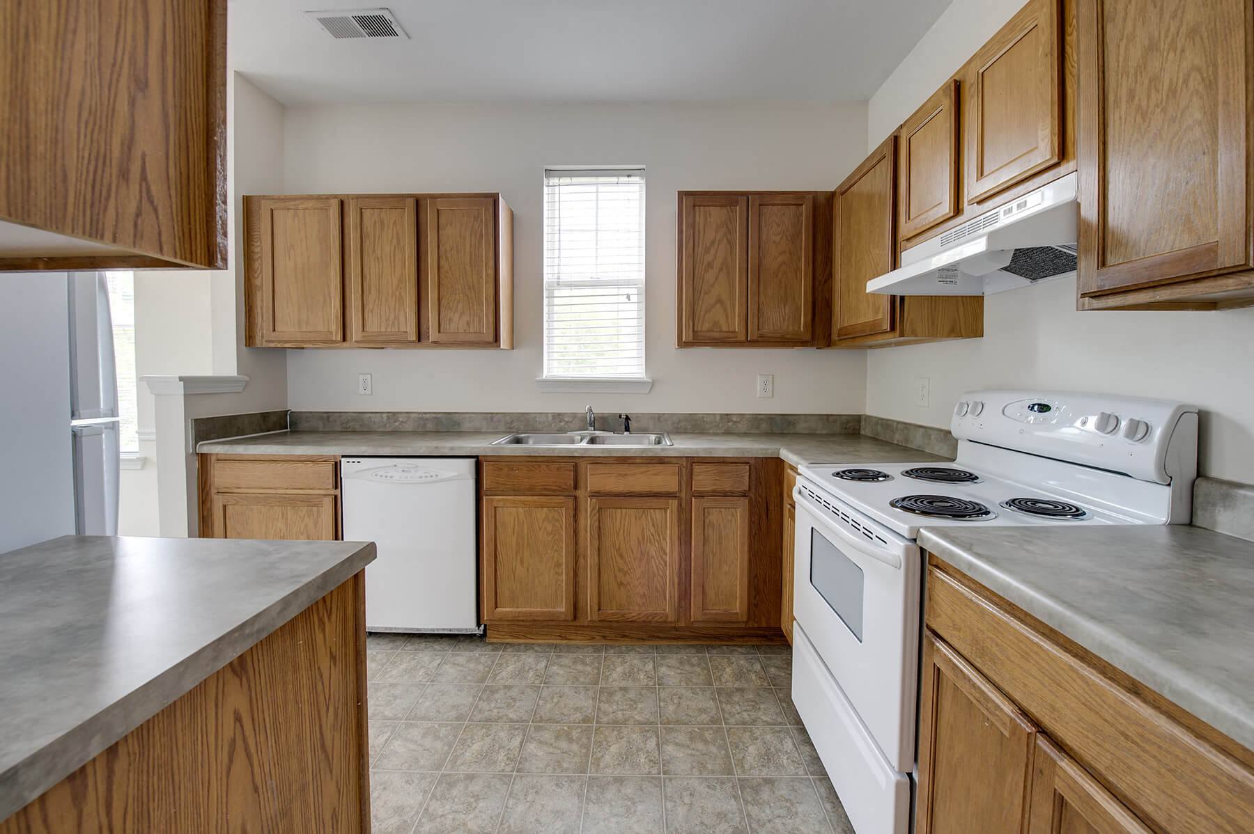 A spacious kitchen with white appliances at the Grand Oaks Apartments in Chester, Virginia.